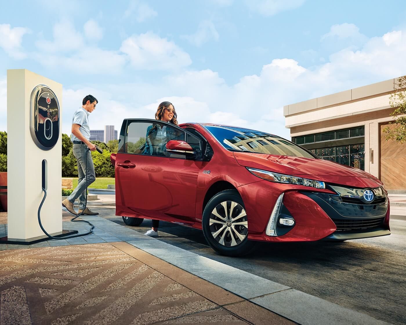 Un couple s'apprêtant à recharger leur Toyota Prius Prime 2022 sur une prise standard à l'extérieur