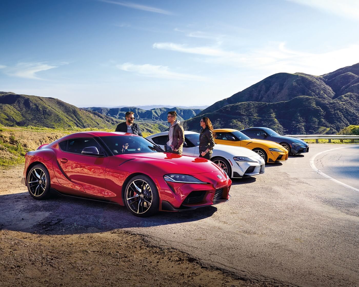Four 2022 Toyota GR Supra in different color choices parked side by side at the side of a road