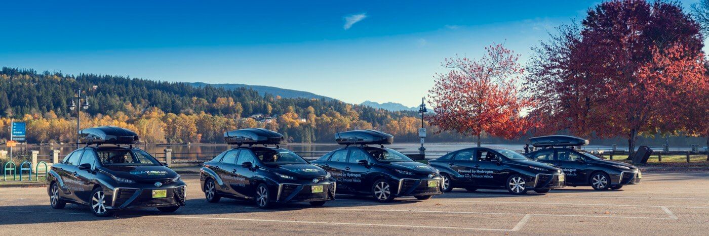 Four Toyota Mirai powered by Hydrogen Zero CO2 Emission Vehicle parked near a lake