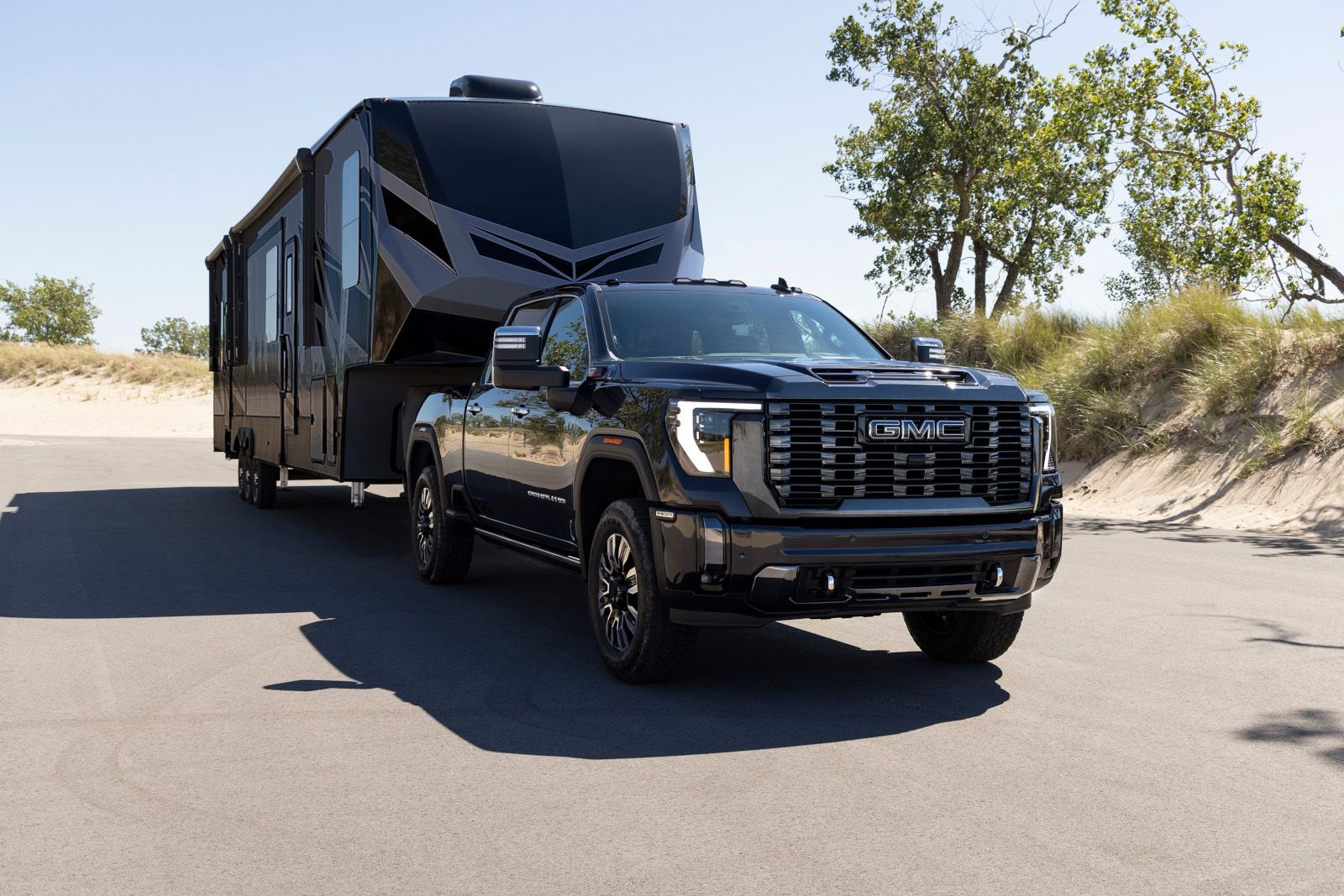 2025 GMC Sierra 2500 HD - front view of a black 2025 GMC Sierra 2500 HD towing a trailer - City GM - GMC car dealership in Toronto, Ontario