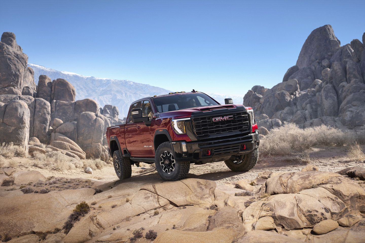 2025 GMC Sierra 2500HD AT4X - a red 2025 GMC Sierra 2500HD AT4X on a rocky off-road trail - Applewood Chevrolet Buick GMC - GMC car dealership in Mississauga, Ontario