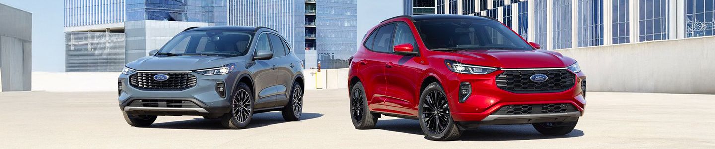2025 Ford Escape Plug-In Hybrid - a red and a grey model parked in front of modern city buildings - Humberview Group - new car dealerships in Ontario