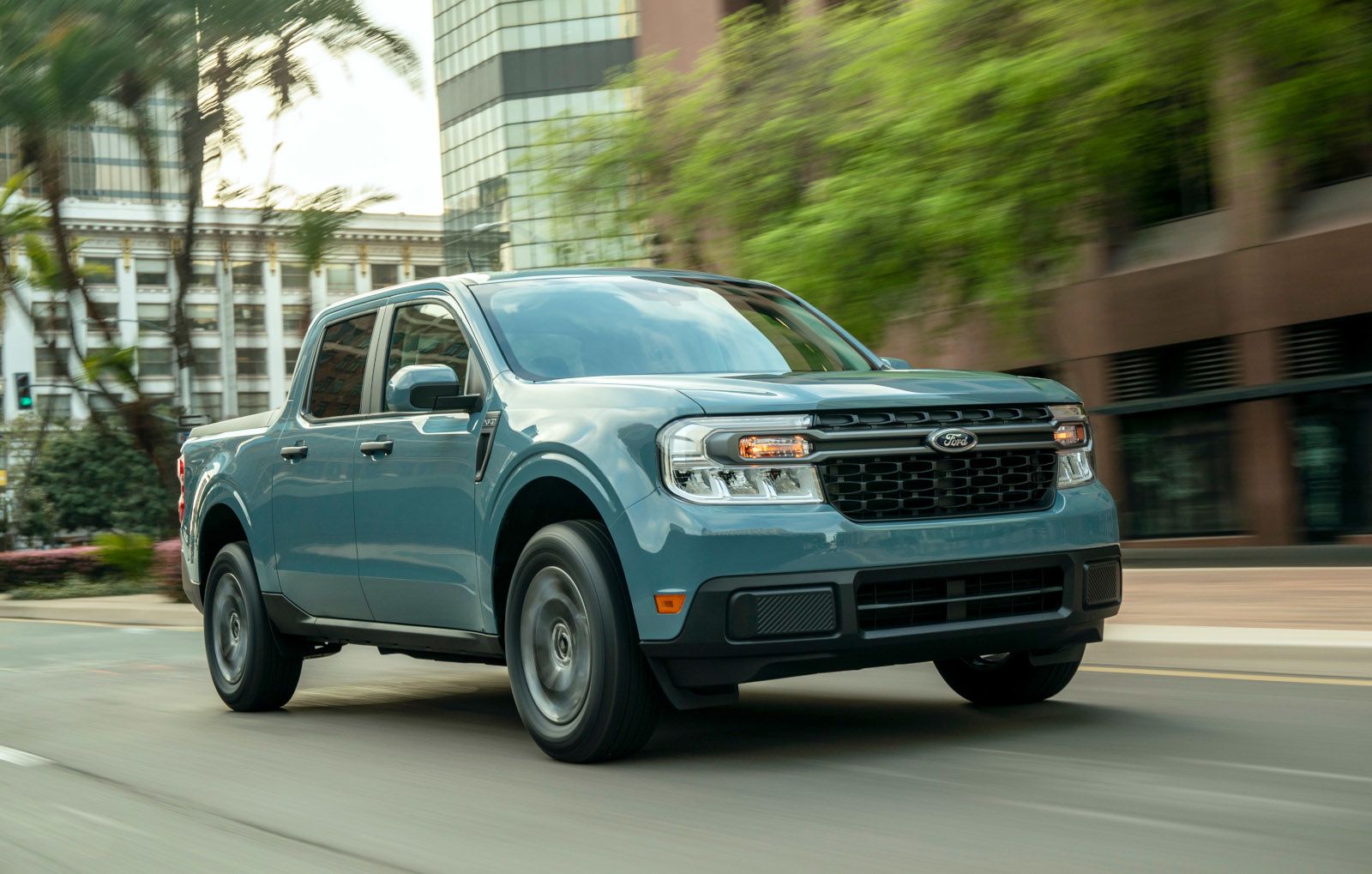 2022 Ford Maverick Hybrid - a blue 2022 Ford Maverick Hybrid driving down a city street - AutoPark Brampton - Pre-owned car dealership in Brampton, Ontario