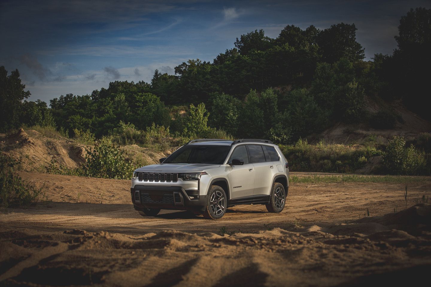 2026 Jeep Cherokee - Front three-quarter view of a silver 2026 Jeep Cherokee on a dirt trail - Cooksville Dodge Chrysler - Jeep car dealership in Mississauga, Ontario