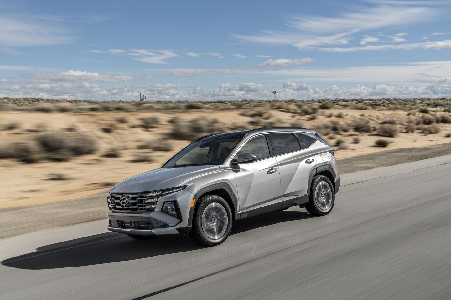 2025 Hyundai Tucson Plug-in Hybrid - A silver 2025 Hyundai Tucson PHEV in motion on a highway, viewed from the front three-quarter angle - Woodstock Hyundai - New car dealership in Woodstock, Ontario