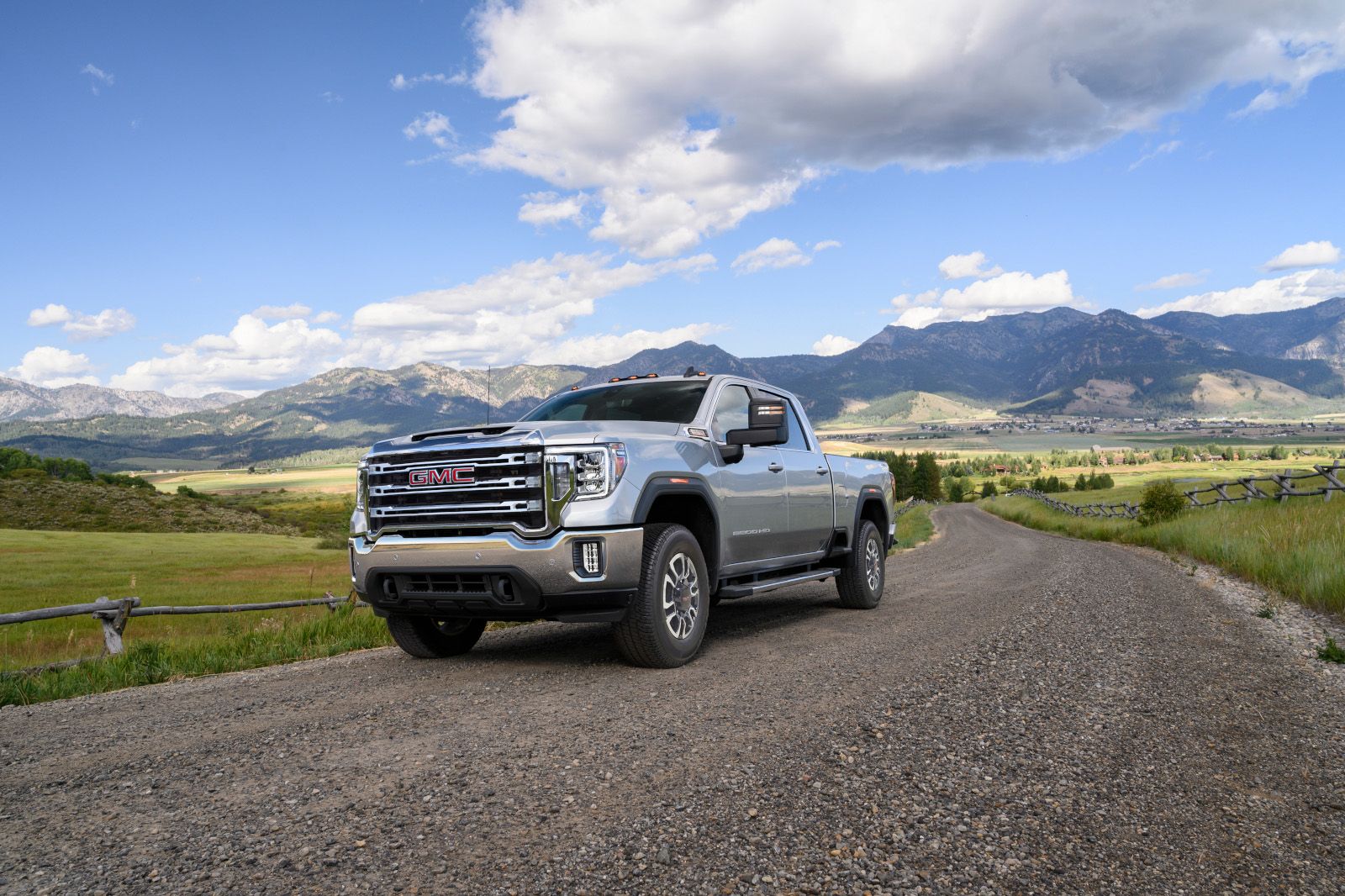 GMC Sierra 2500HD - a silver GMC Sierra 2500HD parked on a gravel road with mountains in the background - Autopark Brampton - Used car dealership in Brampton, Ontario