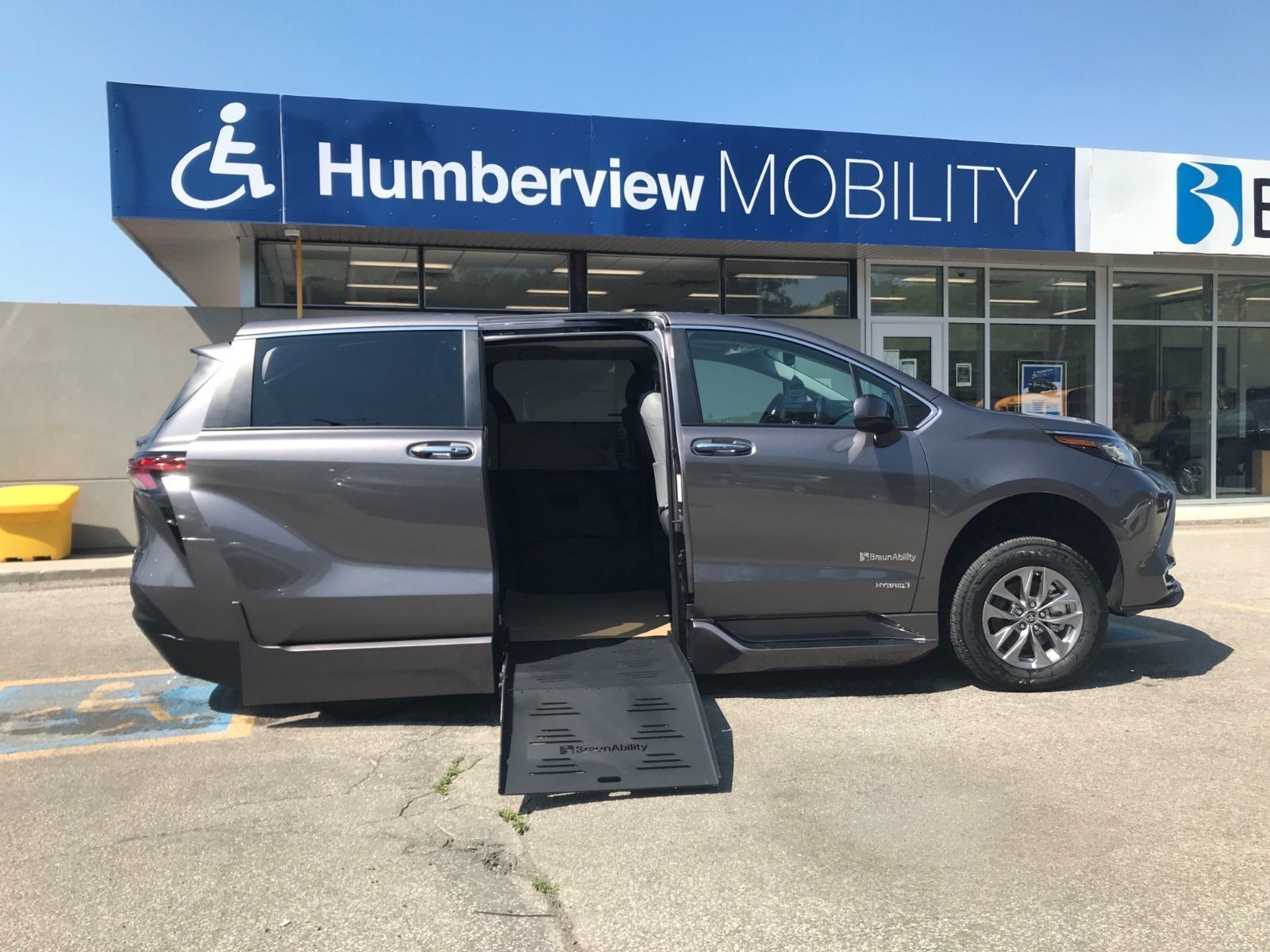 Toyota Sienna - Side view of a gray Toyota Sienna accessible van with the side-entry wheelchair ramp extended - Humberview Mobility - Accessible Vehicle dealership in Toronto, Ontario