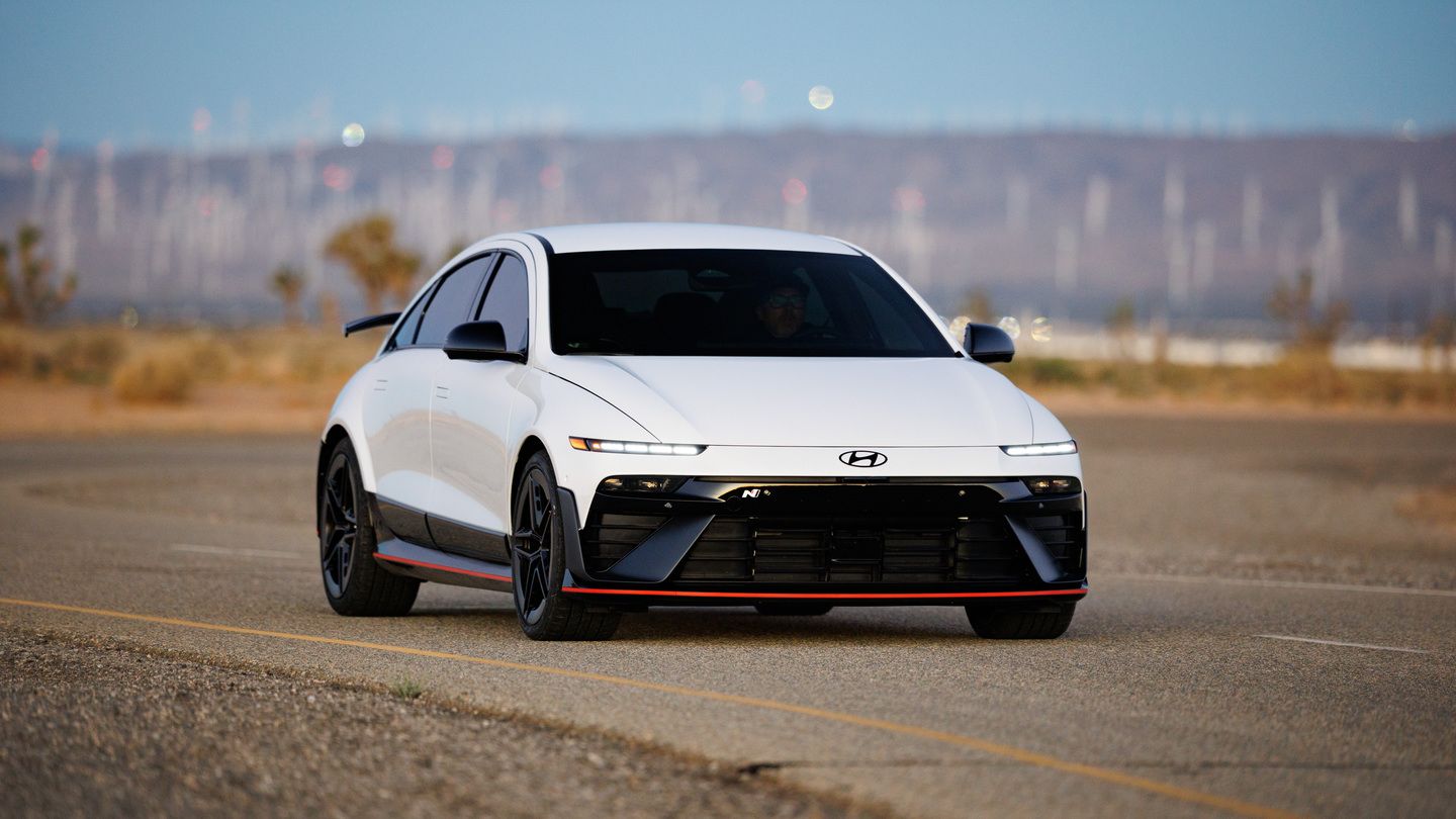 2026 Hyundai IONIQ 6 N - front angle view of a white electric sports sedan driving on a road - Woodstock Hyundai - New car dealership in Woodstock, Ontario