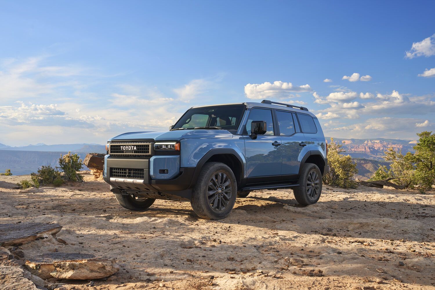 2026 Toyota Land Cruiser - a blue 2026 Toyota Land Cruiser parked on rocky desert terrain - Humberview Group - New car dealerships in Ontario