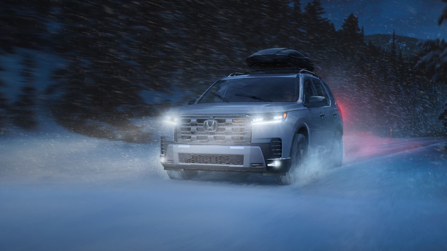 2026 Honda Pilot - a silver 2026 Honda Pilot with a roof cargo box driving on a snowy road at dusk - Goderich Honda - New car dealership in Goderich, Ontario