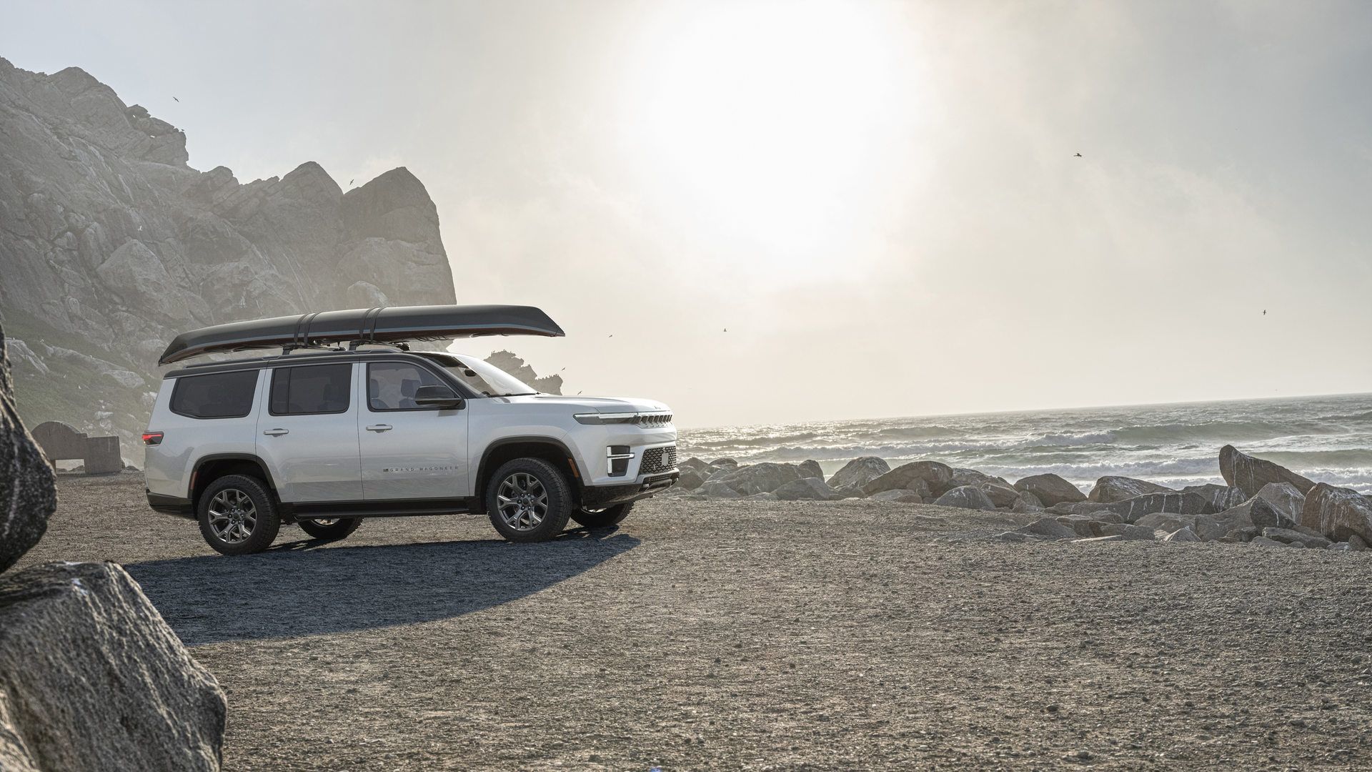 2026 Jeep Grand Wagoneer - side view of a white 2026 Jeep Grand Wagoneer parked on a beach with a canoe on the roof - Humberview Group - New car dealerships in Ontario