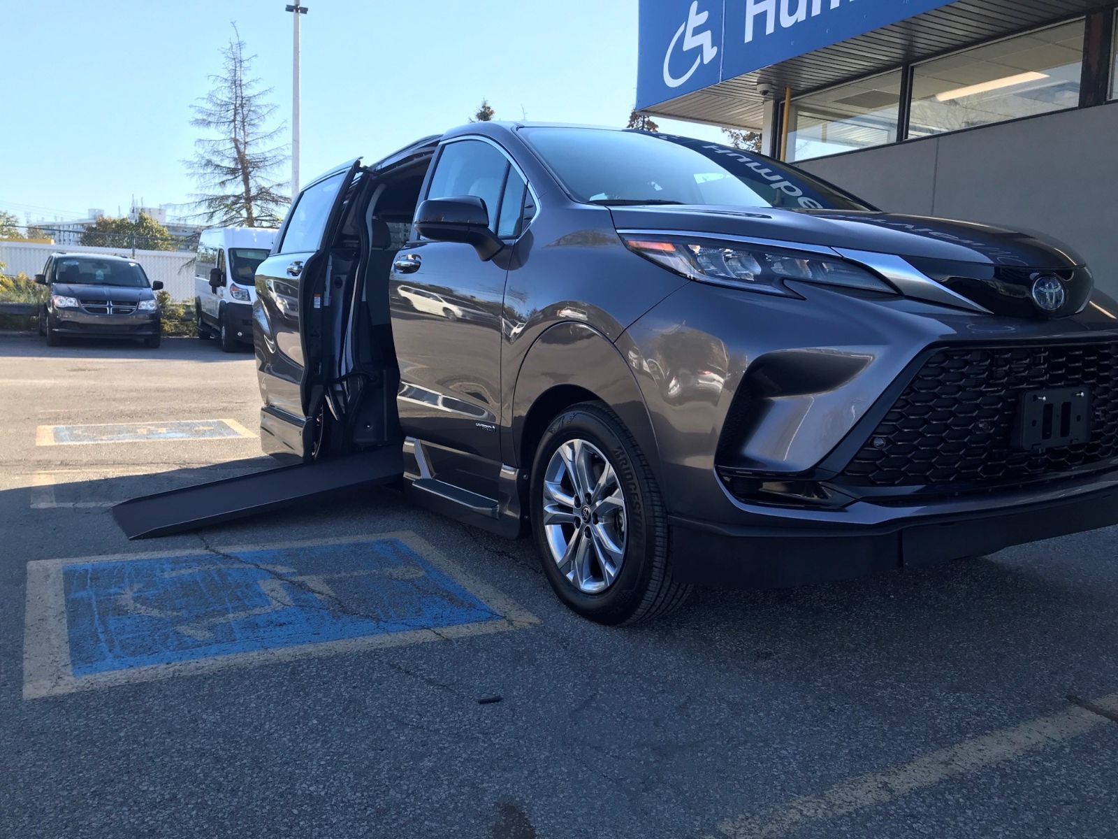 Toyota Sienna - front-angle view of a charcoal 2026 Toyota Sienna with its side-entry wheelchair ramp deployed - Humberview Mobility - Accessible car dealership in Toronto, Ontario