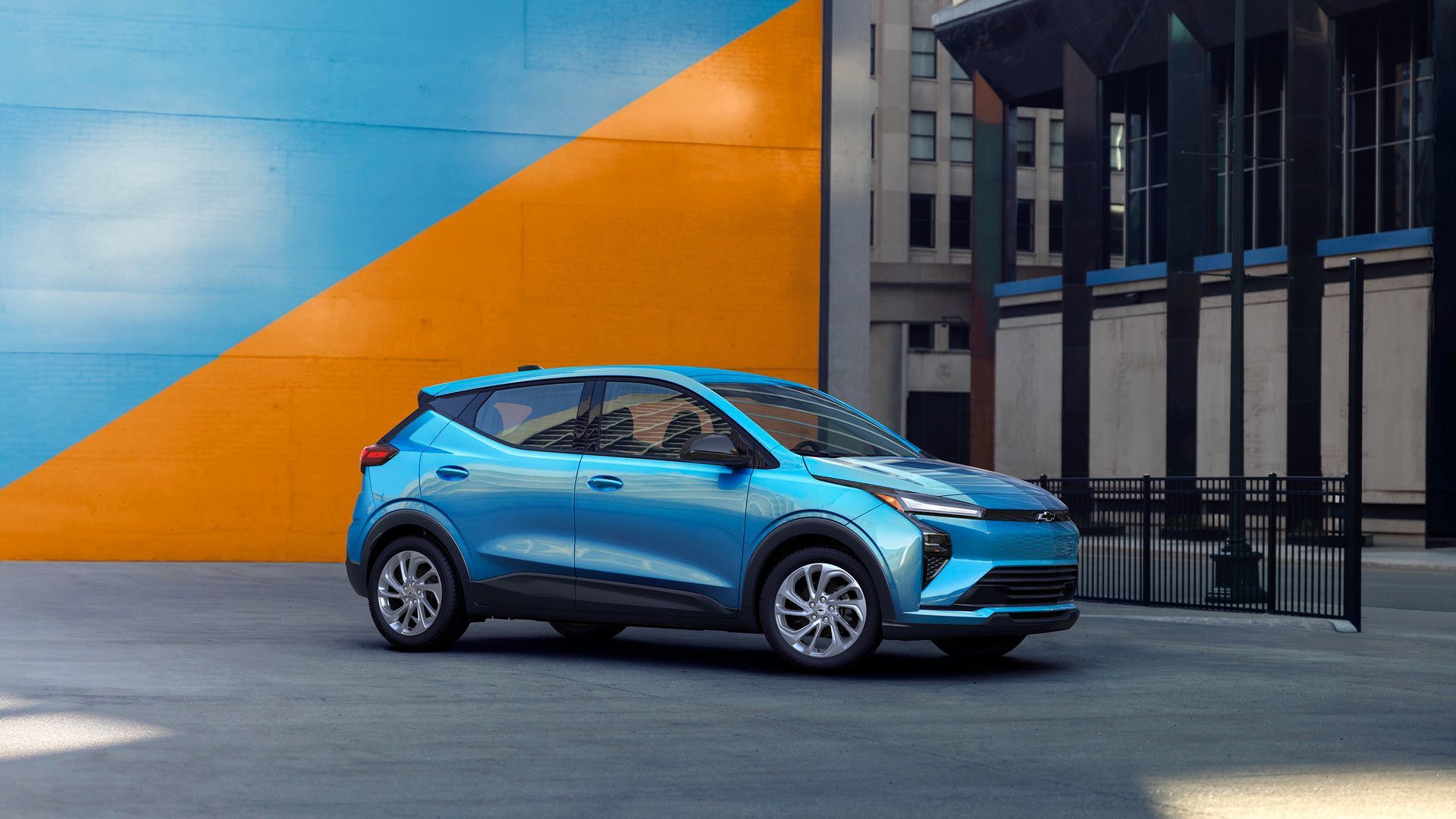 2026 Chevrolet Bolt - passenger-side profile view of a blue 2026 Chevrolet Bolt parked in front of a blue and orange wall - City Chevrolet Buick GMC - New car dealership in Toronto, Ontario