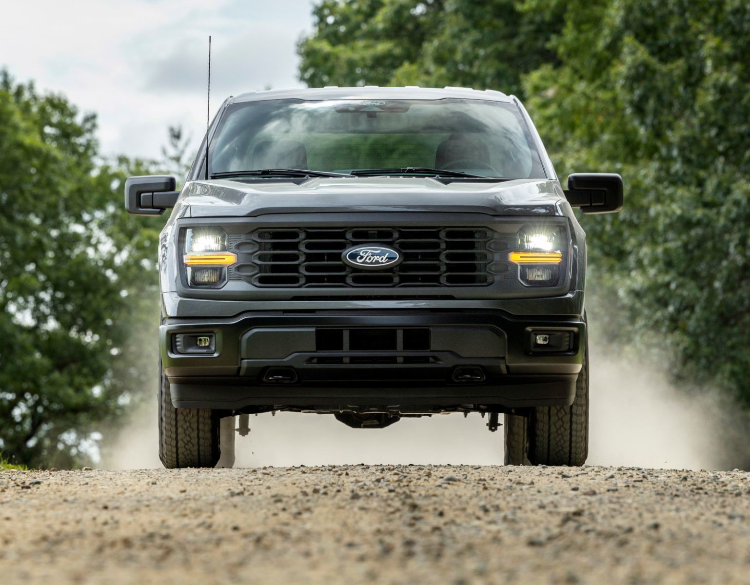 2026 Ford F-150 STX - front view of a grey Ford F-150 driving on a dirt road - Bayfield Ford - New car dealership in Barrie, Ontario