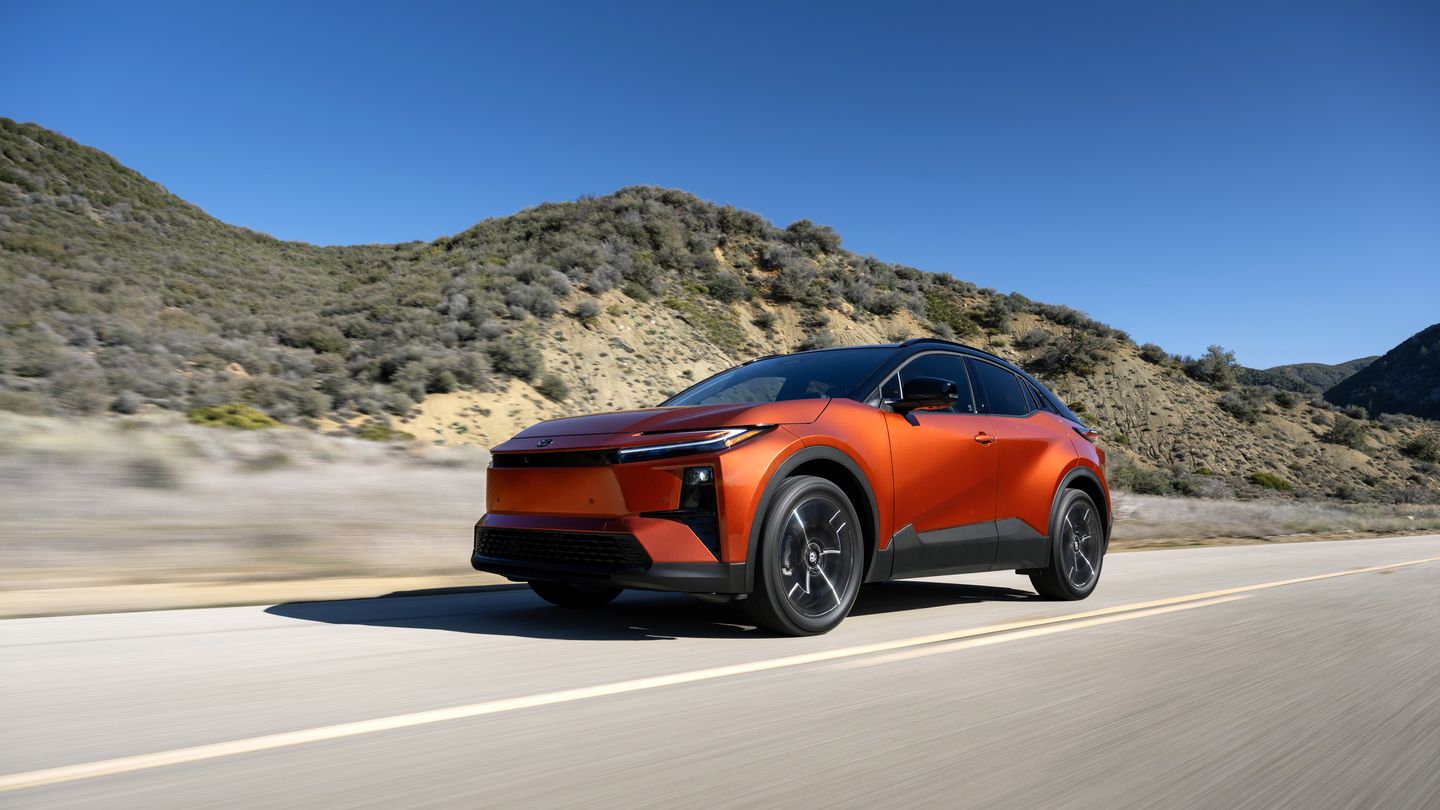 2026 Toyota C-HR - Front three-quarter view of an orange 2026 Toyota C-HR XSE driving on a paved road through hills - Orangeville Toyota - New car dealership in Orangeville, Ontario
