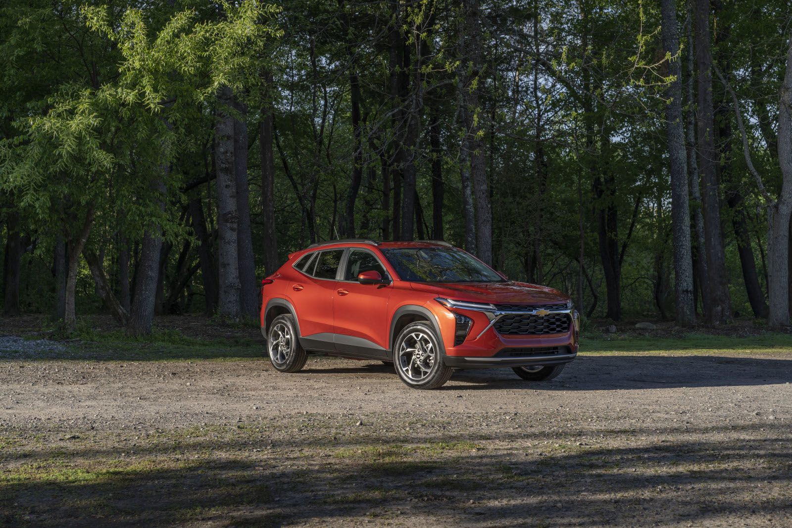 2026 Chevrolet Trax - Front three-quarter view of an orange Chevrolet Trax LT parked near a wooded area - Humberview Chevrolet, Buick, GMC - New car dealership in Toronto, Ontario