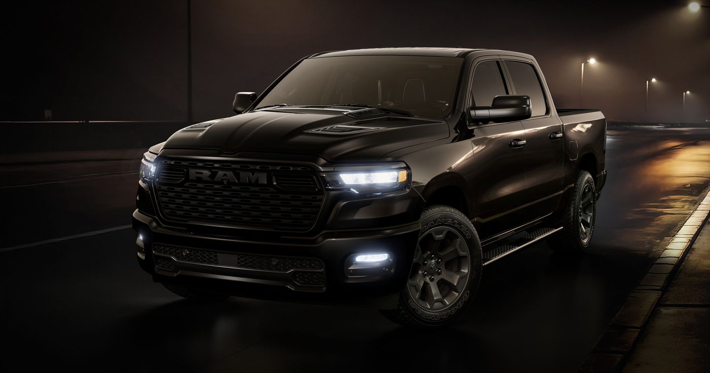 2026 Ram 1500 - front three-quarter view of a black 2026 Ram 1500 pickup truck parked on a wet street at night under streetlights - Cooksville Dodge - New car dealership in Mississauga, Ontario
