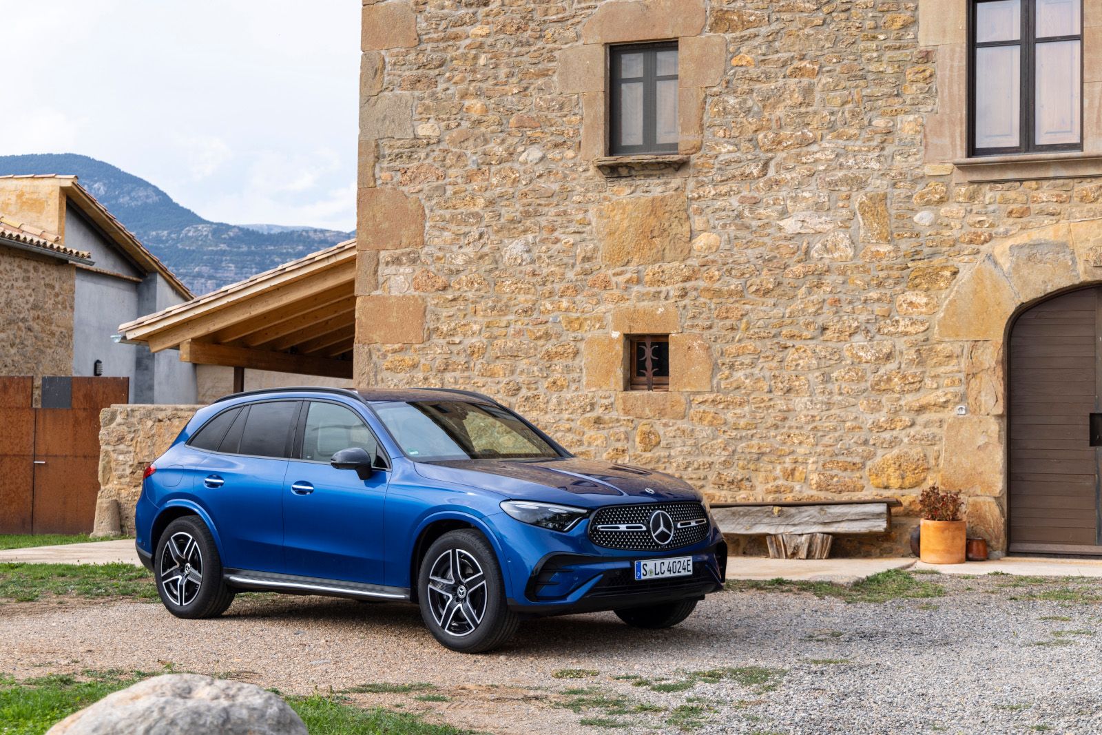 2026 Mercedes-Benz GLC - A blue Mercedes-Benz GLC SUV parked in front of a historic stone building - Humberview Group - New car dealerships in Ontario