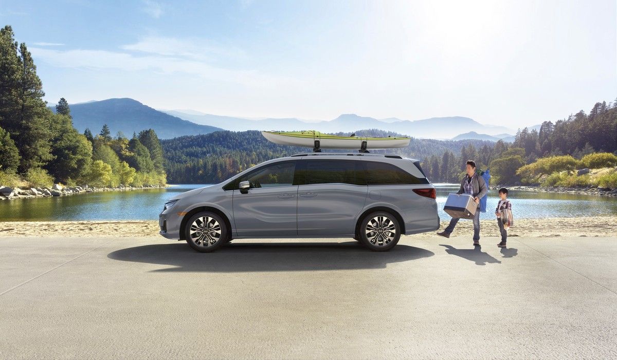 2026 Honda Odyssey - side profile of a silver 2026 Honda Odyssey parked by a lake with a kayak on the roof - Orangeville Honda - New car dealership in Orangeville, Ontario