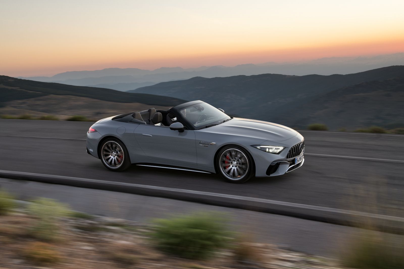 2026 Mercedes-Benz SL-Class - side view of a grey 2026 Mercedes-Benz SL-Class convertible driving along a mountain road at sunset - Humberview Group - Mercedes-Benz new car dealerships in Ontario