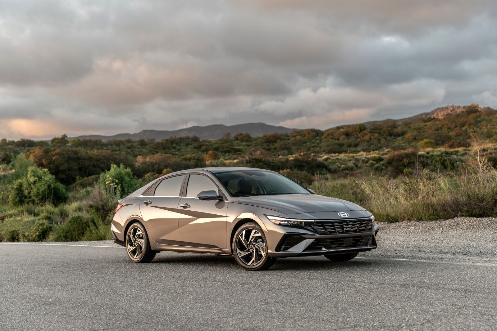 2026 Hyundai Elantra - front three-quarter view of the 2026 Hyundai Elantra parked on an asphalt road with a mountain background - Cooksville Hyundai - Hyundai new car dealership in Mississauga, ON