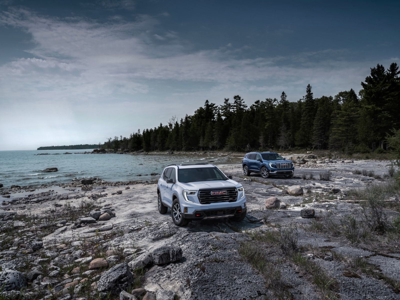 2026 GMC Acadia - front view of a white 2026 GMC Acadia AT4 parked on a rocky shoreline - City Chevrolet, Buick, GMC - GMC car dealership in Toronto, Ontario