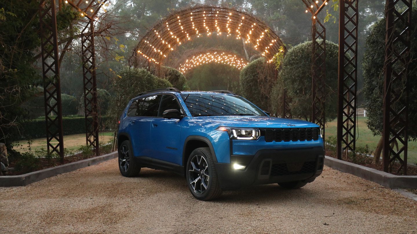2026 Jeep Cherokee - A bright blue Jeep Cherokee parked on a gravel driveway under a decorative archway with lights - Cooksville Chrysler, Jeep, Dodge - New car dealership in Mississauga, Ontario