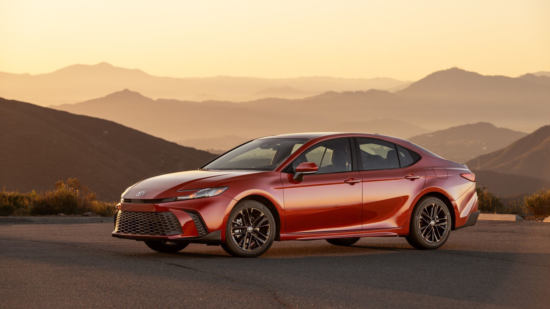 2026 Toyota Camry - a red 2026 Toyota Camry parked on a scenic mountain road at sunset - Goderich Toyota - Toyota new car dealership in Goderich, Ontario