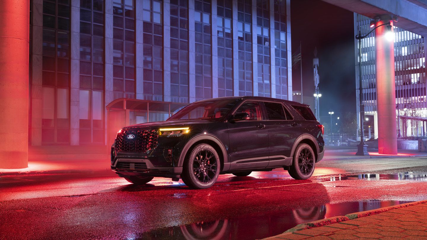 2027 Ford Explorer - front three-quarter view of a black 2027 Ford Explorer parked on a wet city street at night - Bayfield Ford - Ford new car dealership in Barrie, Ontario