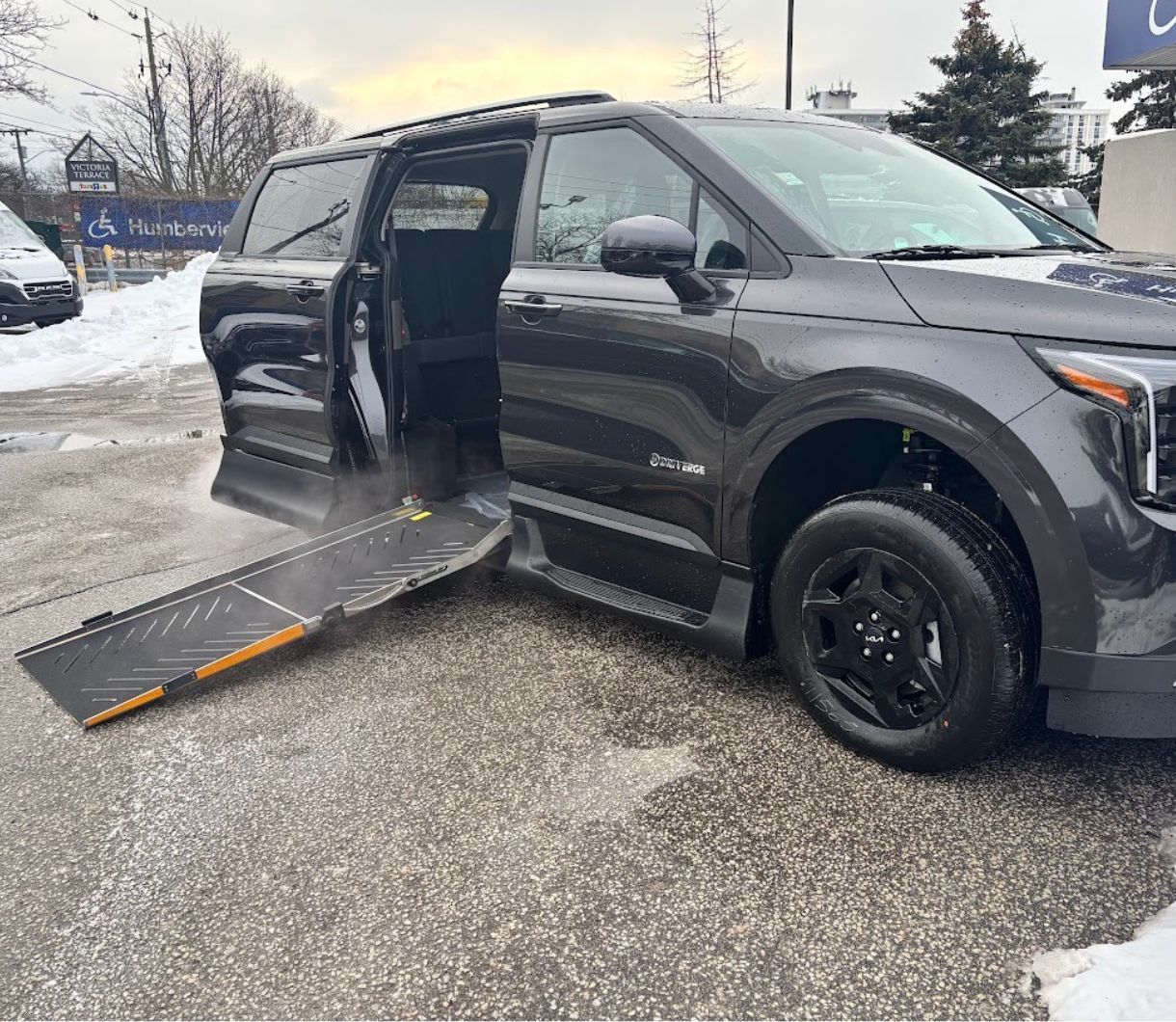 Kia Carnival - a dark grey Kia Carnival with an accessible side entry ramp extended - Humberview Mobility - Accessible car dealership in Toronto, Ontario