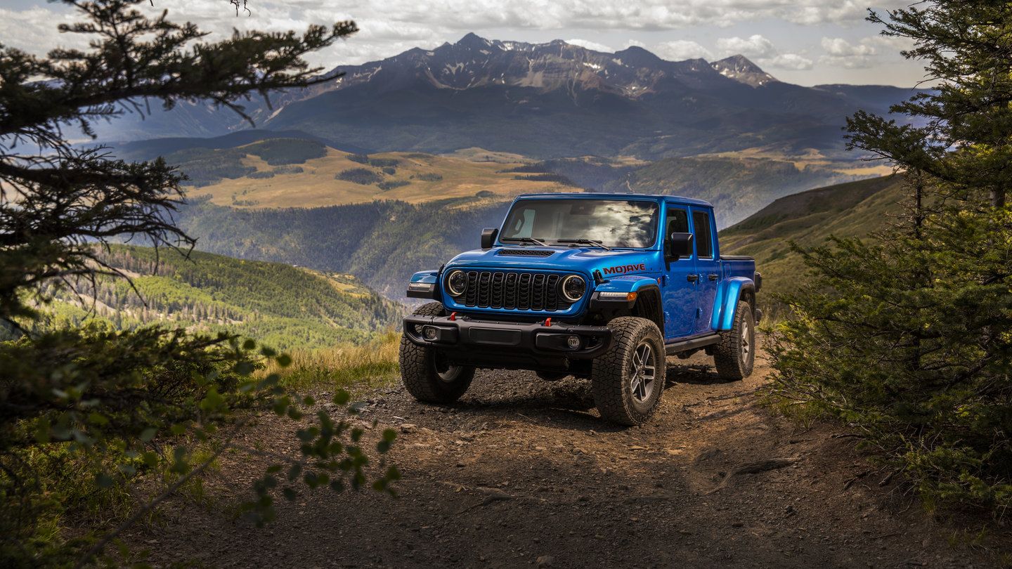 2027 Jeep Gladiator - front three-quarter view of a blue 2027 Jeep Gladiator Mojave parked on a dirt mountain trail - Cooksville Chrysler, Jeep, Dodge, Ram - Jeep car dealership in Mississauga, Ontario