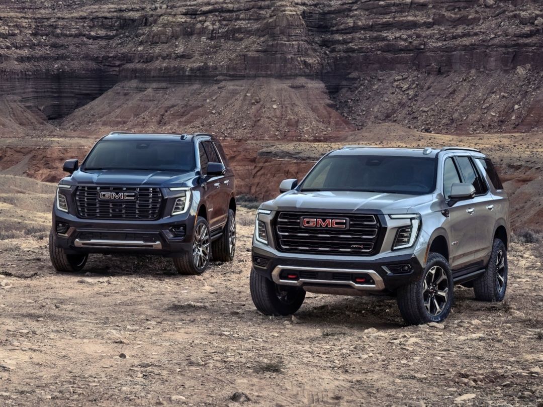 Deux VUS GMC Yukon 2025 à l'extérieur.