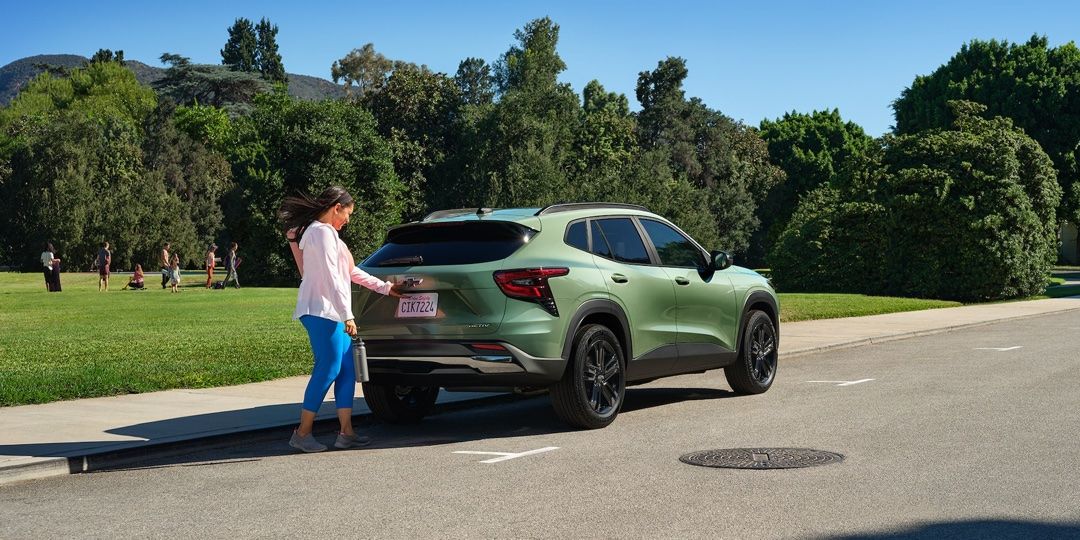 Une femme qui ouvre le coffre de son Chevrolet Trax 2025.