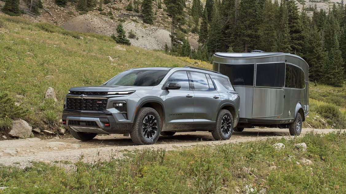 Le Chevrolet Traverse 2024 qui tire une petite remorque sur un chemin escarpé de montagne.