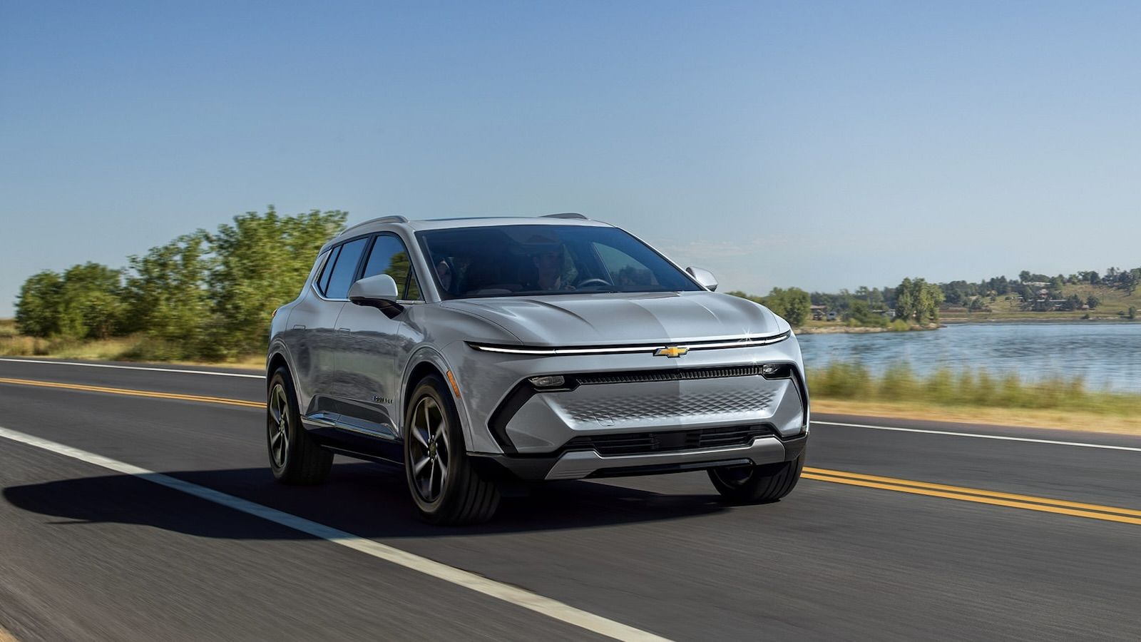 Le Chevrolet Equinox EV 2025 sur une route au bord de l'eau.