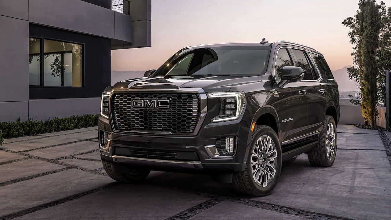 Le GMC Yukon stationné devant une grande résidence au bord de l'eau.