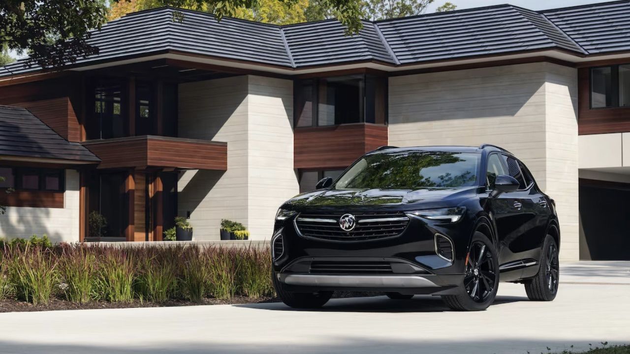 Le Buick Envision stationné devant une grande résidence.