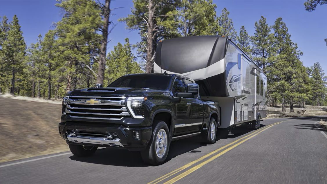 Le Chevrolet Silverado HD 2025 qui tire une roulotte en forêt.