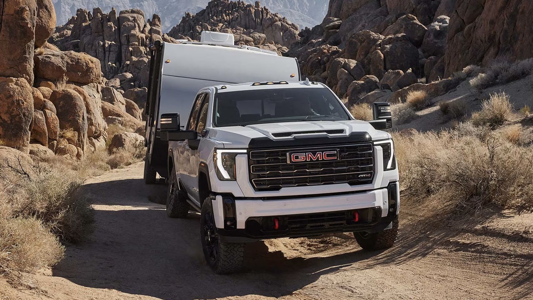 Le GMC Sierra HD 2025 qui tire une roulotte au milieu d'un canyon.