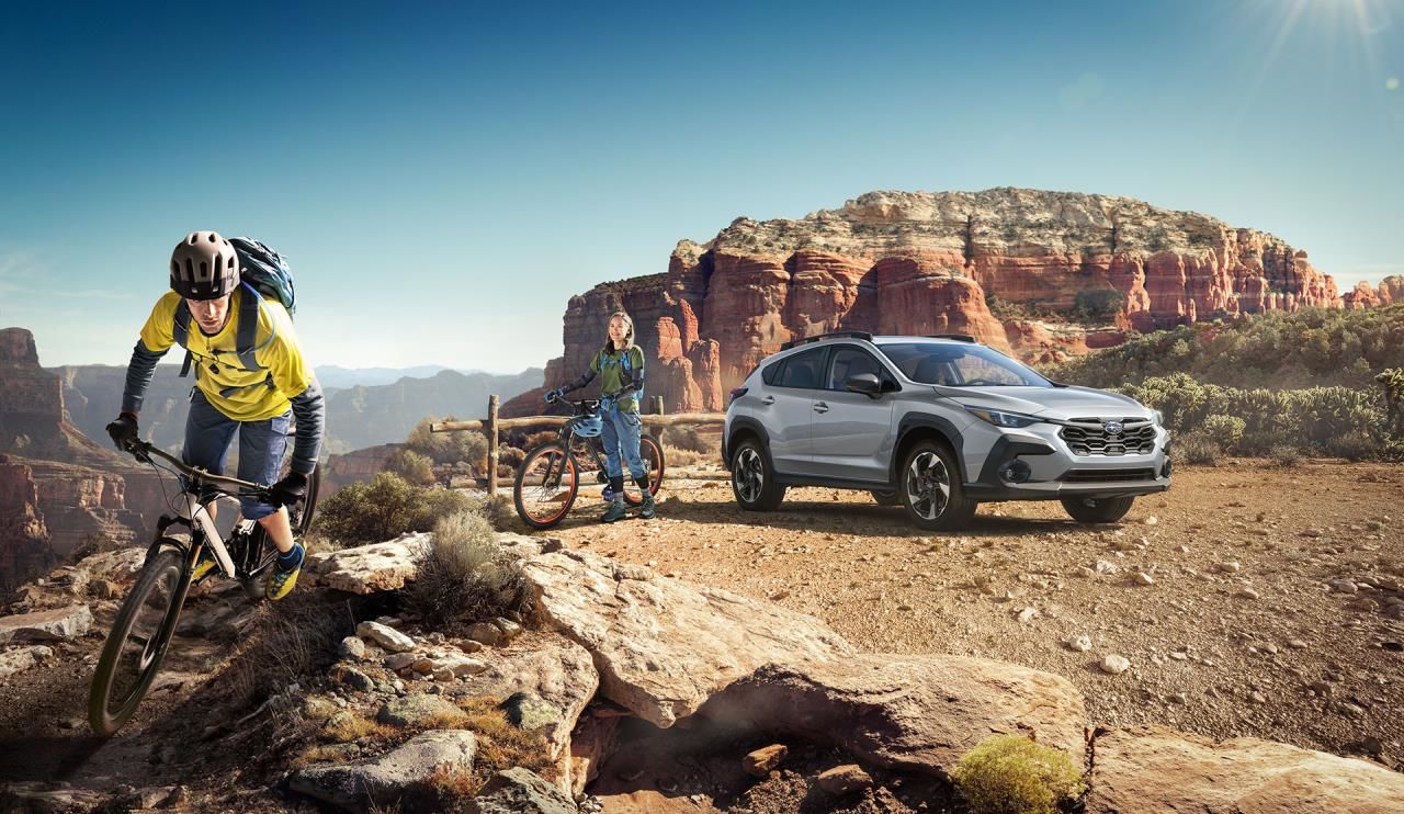 Vue 3/4 avant du Subaru Crosstrek 2024 situé dans un canyon avec deux cyclistes partant à l'aventure.