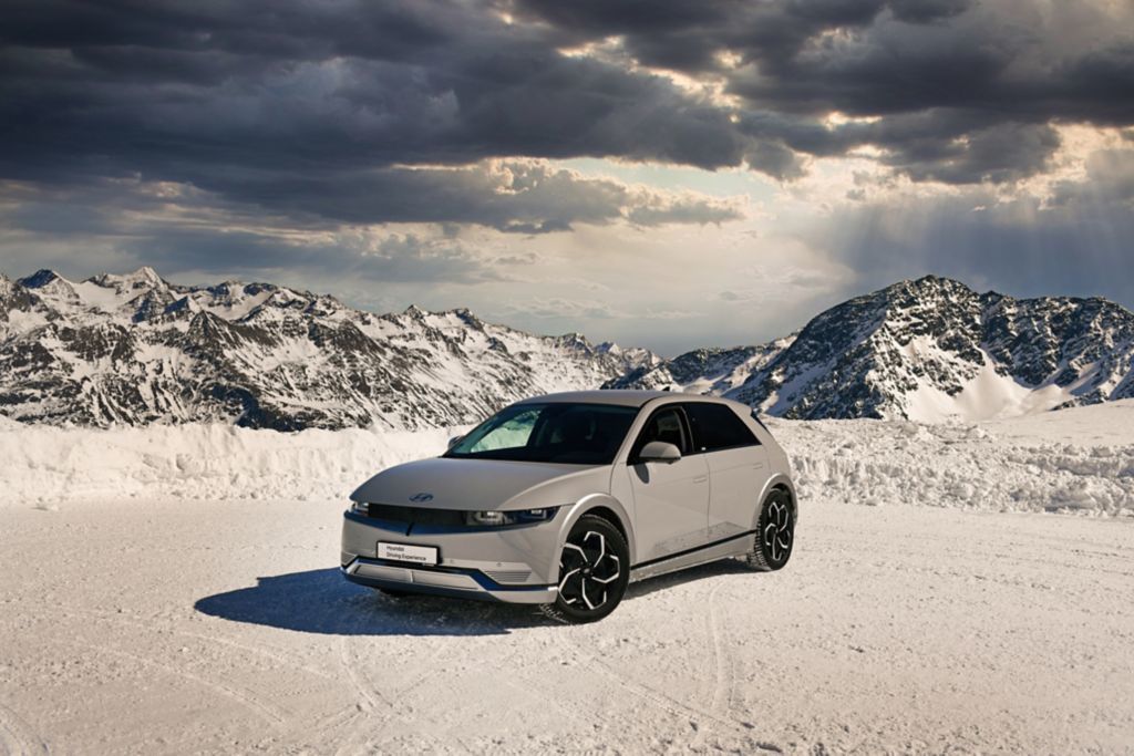 Un véhicule électrique Hyundai Ioniq 5 garé sur une surface en hiver avec des rocheuses en arrière-plan.