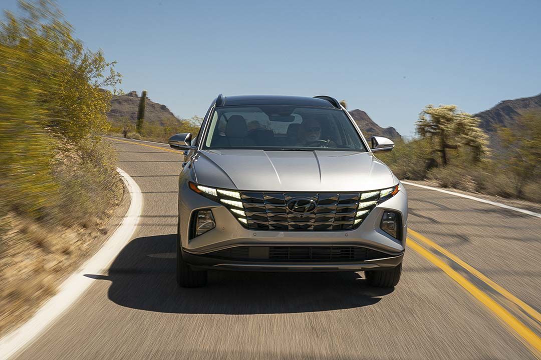 Vue avant du VUS Hyundai Tucson Hybride 2022 roulant sur une route en plein jour