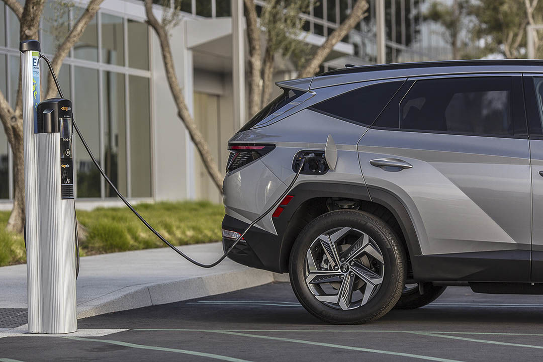 Le Hyundai Tucson PHEV 2022 rechargeant sa batterie par la borne électrique à l'extérieur