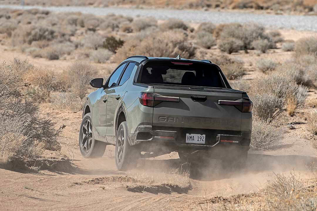 Vue arrière d'un Hyundai Santa Cruz 2022 gris performant hors-route dans un désert