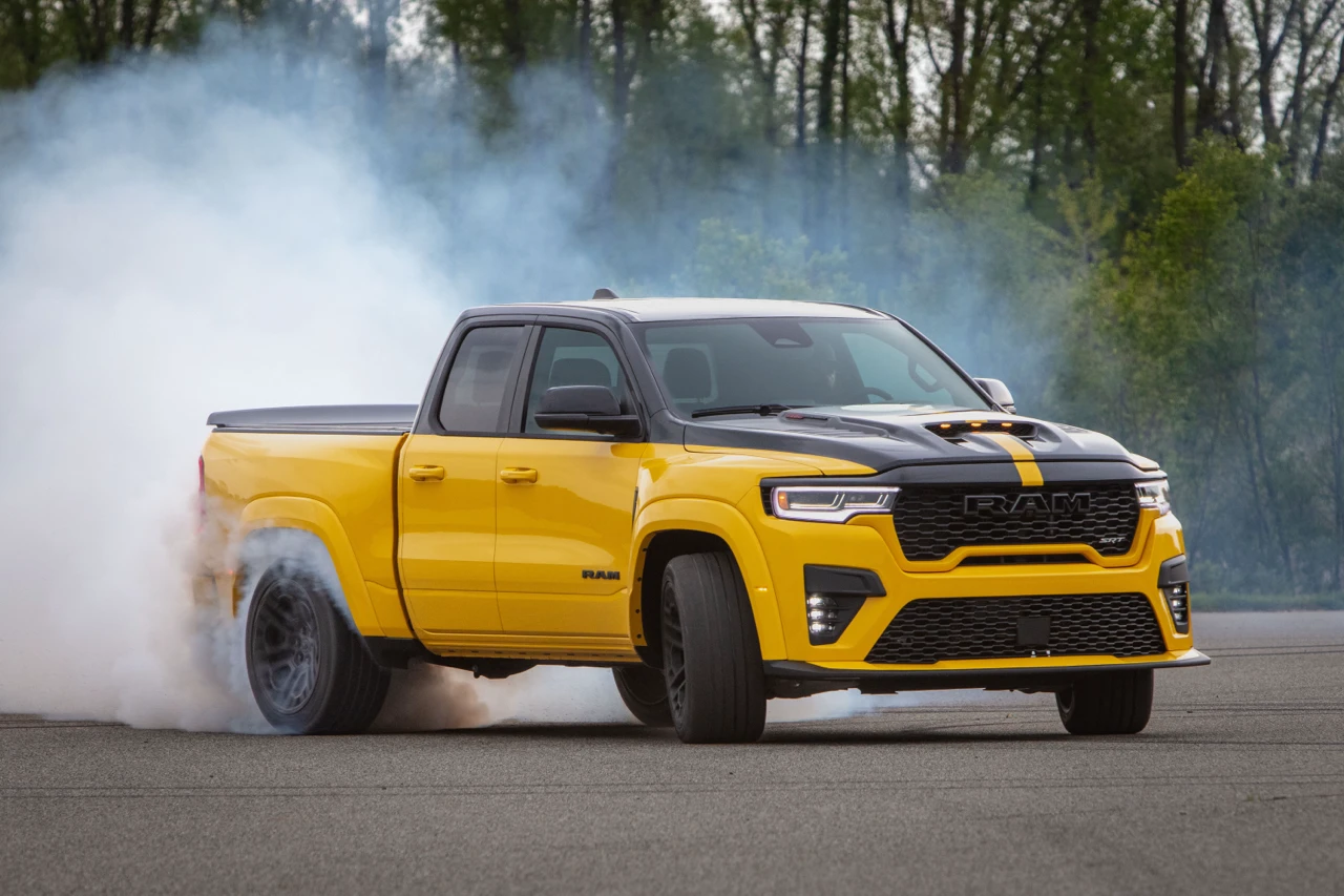 Yellow 2027 Ram 1500 Rumble Bee performing a burnout with smoke rising from its rear tires.
