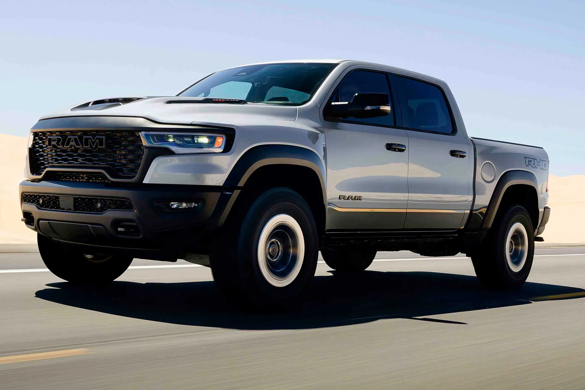 Silver Ram 1500 RHO driving on a paved road with wide fenders and off-road tires.