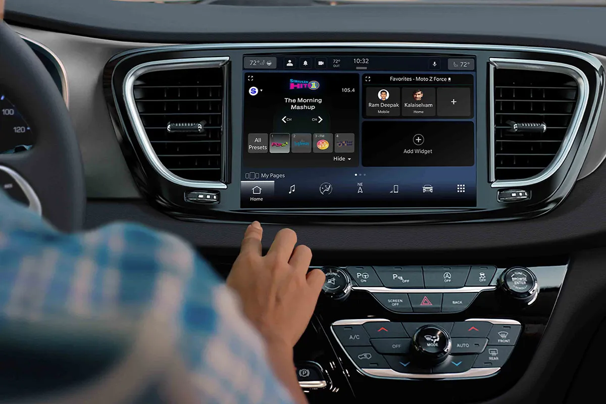 Chrysler Grand Caravan dashboard with a central Uconnect touchscreen and physical climate controls.