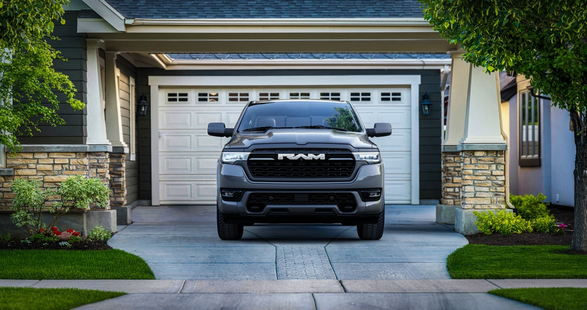 Front view of a grey Ram 1500 REV parked in a residential driveway in front of a garage.