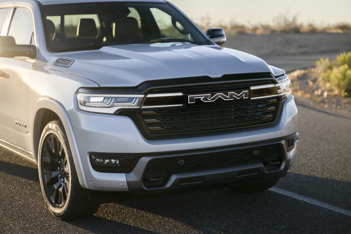White Ram 1500 REV shown from the front three-quarter angle, highlighting its grille, headlights and hood.