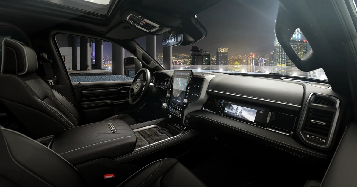 Ram 1500 REV front cabin showing the central touchscreen, passenger display, steering wheel and centre console.